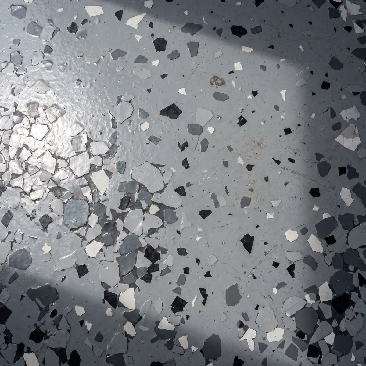 Close view of the same gray, black and white blend in the large chip size, dark base coat showing between the chips