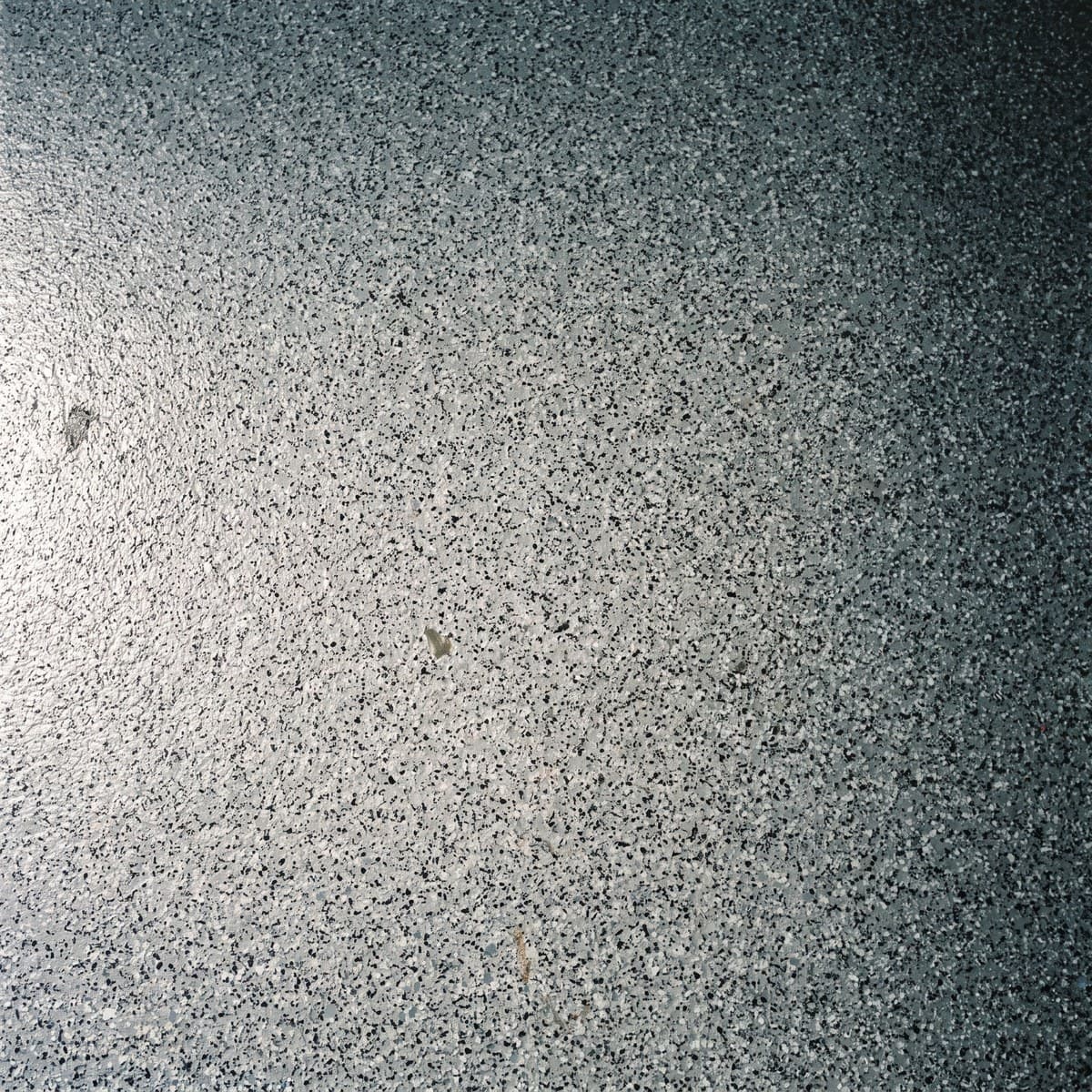 Close view of a gray, black and white flake floor in the small chip size, the chip reading as one fine, even texture