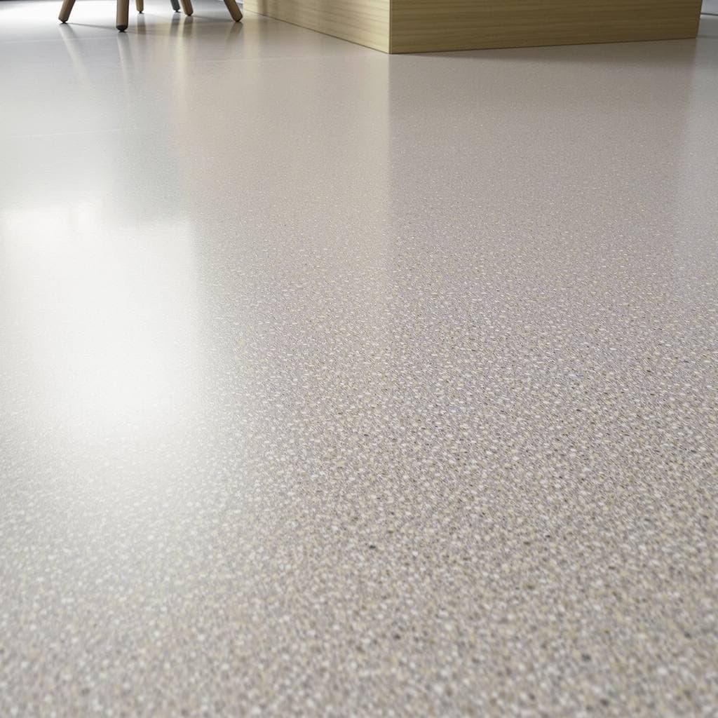 A honed concrete floor seen at a low angle, the overhead light lying on it as a wide soft glow with no defined edge
