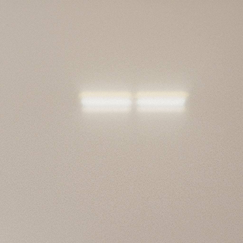 A satin polished concrete floor seen at a low angle, the overhead light reading as a bright soft-edged band without anything legible in it
