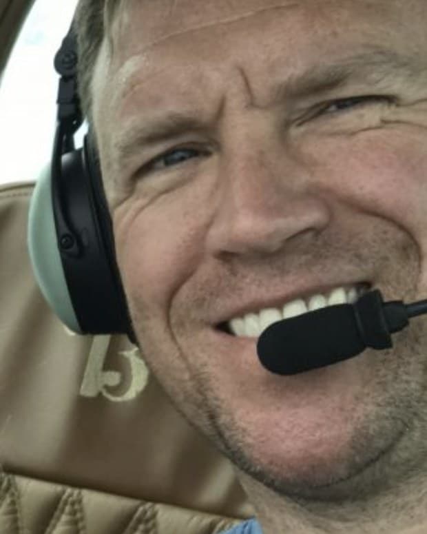 Our founder in the cockpit of a small airplane, headset on, smiling at the camera